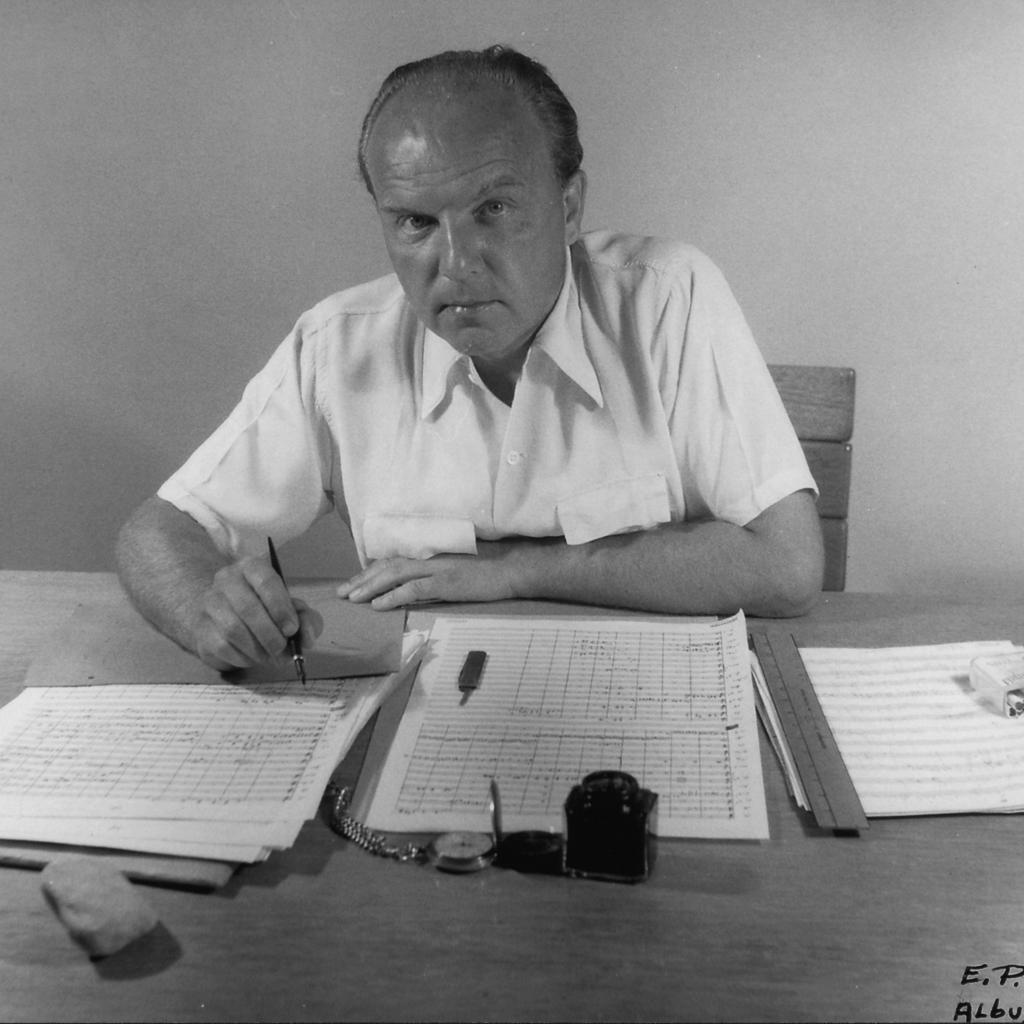 Ernst Krenek am Tisch sitzend und schreibend, Portrait
