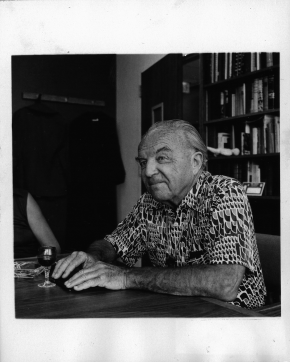 Ernst Krenek, fast Linksprofil, an einem Tisch sitzend, vor ihm ein Glas Wein, gemustertes Hemd, an der CSUN (California State University Northridge)