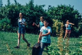 Musikvermittlung Veronika Großberger Schülerinnen und Schüler gehen mit Koffer auf Wiese, Ernst Krenek