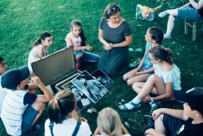 Musikvermittlung Veronika Großberger Schülerinnen und Schüler sitzen um einen Koffer auf Wiese, Ernst Krenek